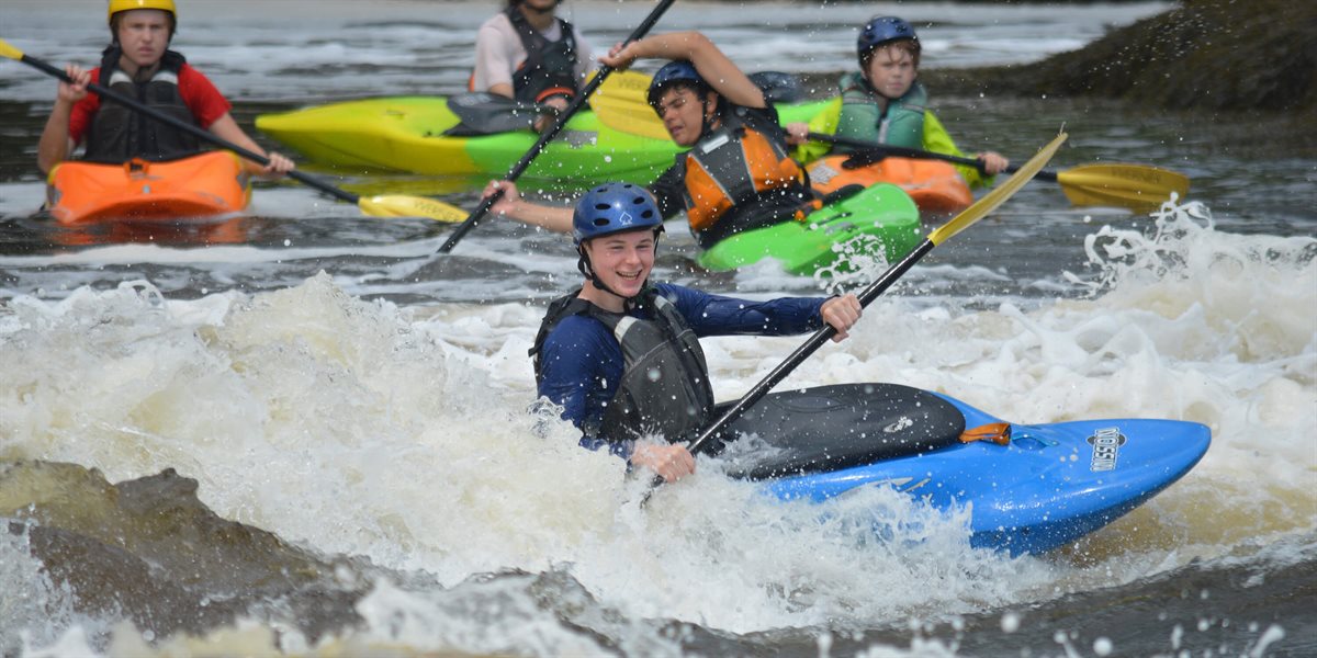 Boys whitewater kayaking