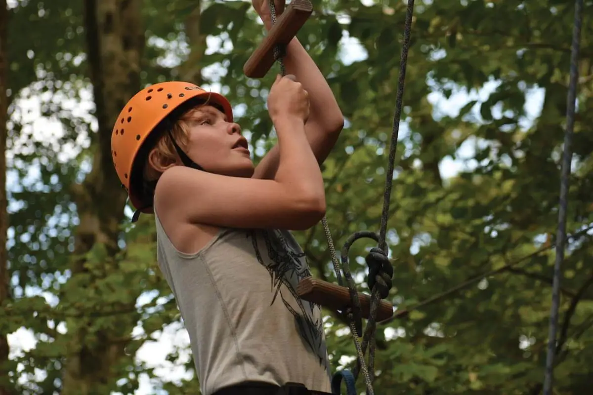 Boy tackling the challenge course at Camp Kabeyun 
